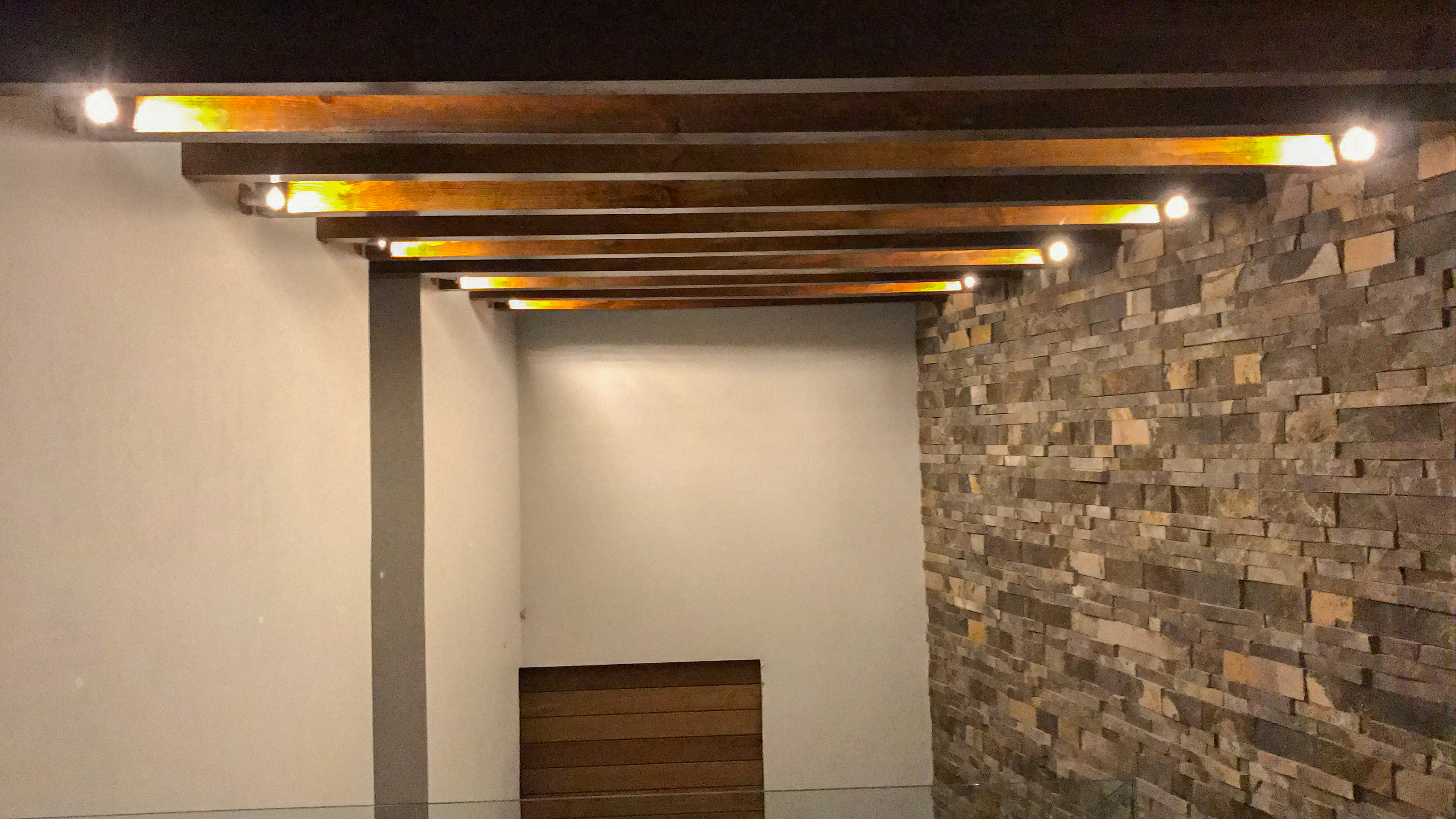 Interior de sala con acabados en madera y techo con vigas expuestas en Casa MG, constructora Fer Et Ciment Guanajuato